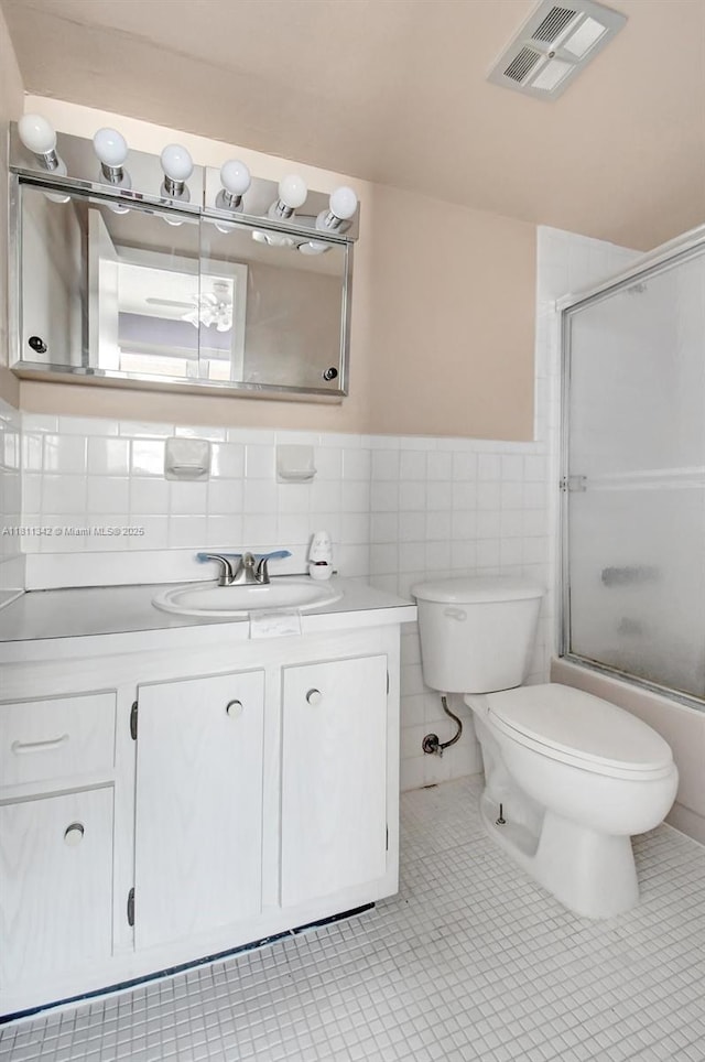 6211 SW 37th St Unit 211, Davie, FL 33314 - bathroom with vanity, toilet, tile walls, shower / bath combination with glass door, and wainscoting