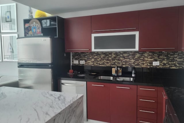 244 Biscayne Blvd Unit 644, Miami, FL 33132 - kitchen featuring a sink, red cabinets, freestanding refrigerator, and tasteful backsplash