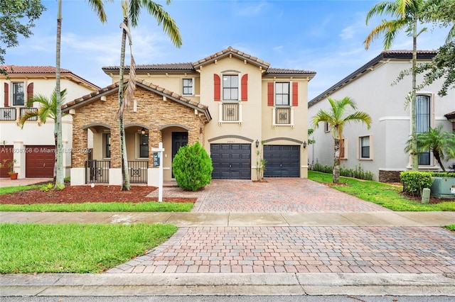 24083 SW 112th Pl, Homestead, FL 33032 - mediterranean / spanish home with stucco siding, decorative driveway, an attached garage, a tile roof, and a porch