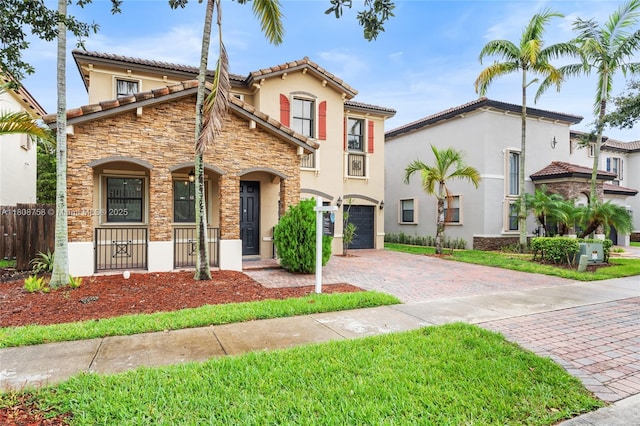 24083 SW 112th Pl, Homestead, FL 33032 - view of front facade featuring stucco siding, stone siding, covered porch, and decorative driveway