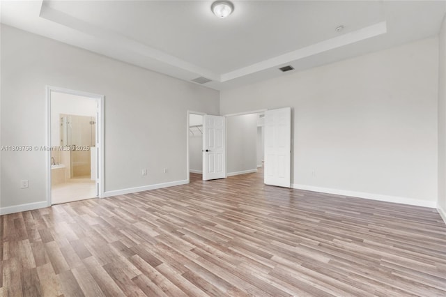 24083 SW 112th Pl, Homestead, FL 33032 - unfurnished bedroom featuring light wood-type flooring, a raised ceiling, a spacious closet, and a high ceiling