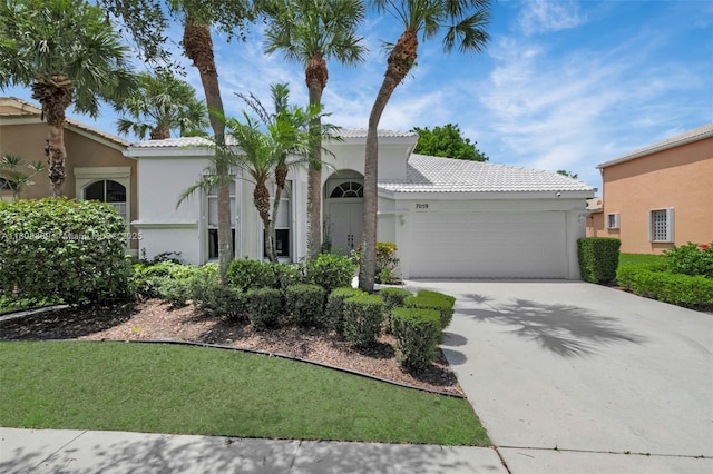 7059 Copperfield Cir, Lake Worth, FL 33467 - mediterranean / spanish-style house with an attached garage, stucco siding, a tile roof, and driveway