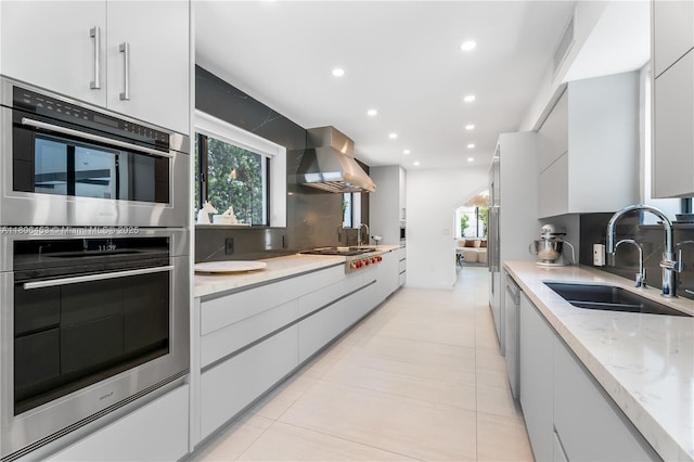5970 Alton Rd, Miami Beach, FL 33140 - kitchen with a sink, wall chimney exhaust hood, stainless steel appliances, modern cabinets, and tasteful backsplash