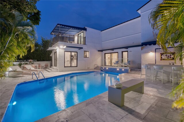 5970 Alton Rd, Miami Beach, FL 33140 - pool at twilight featuring a patio, an outdoor pool, french doors, and a hot tub