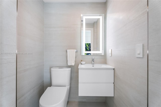 5970 Alton Rd, Miami Beach, FL 33140 - half bath featuring vanity, toilet, and tile walls