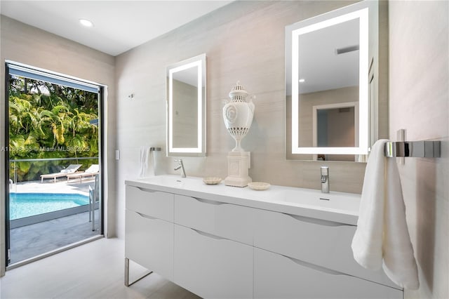 5970 Alton Rd, Miami Beach, FL 33140 - bathroom with double vanity, tile walls, and decorative backsplash