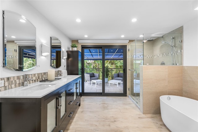 5970 Alton Rd, Miami Beach, FL 33140 - full bath featuring a stall shower, double vanity, a freestanding bath, wood finished floors, and recessed lighting