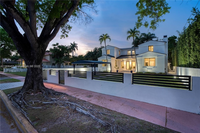 5970 Alton Rd, Miami Beach, FL 33140 - view of front of property with a fenced front yard, stucco siding, and metal roof