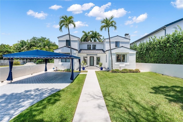 5970 Alton Rd, Miami Beach, FL 33140 - view of front of property with a standing seam roof, stucco siding, a chimney, metal roof, and decorative driveway