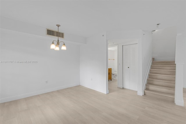 12154 Saint Andrews Pl Unit 112, Miramar, FL 33025 - unfurnished room featuring light wood-style flooring, a chandelier, stairs, and baseboards