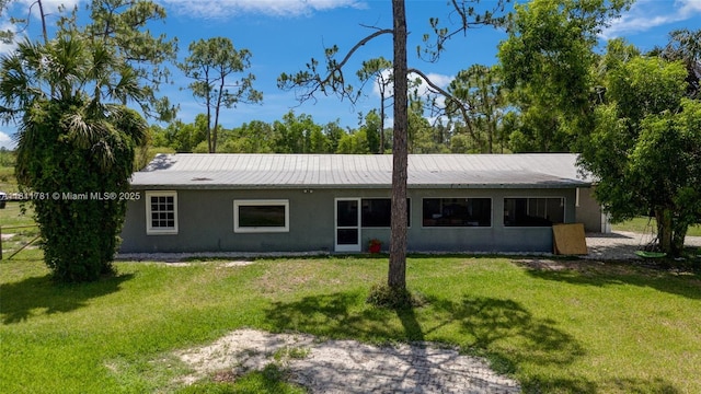40691 Suzan Dr, Punta Gorda, FL 33982 - back of house with stucco siding, a lawn, and metal roof