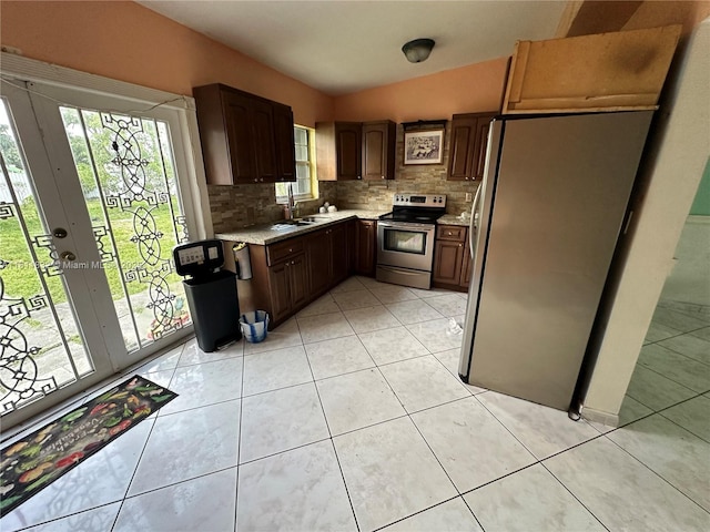 315 W 44th St, Hialeah, FL 33012 - kitchen featuring stainless steel appliances, backsplash, light tile patterned floors, a sink, and french doors