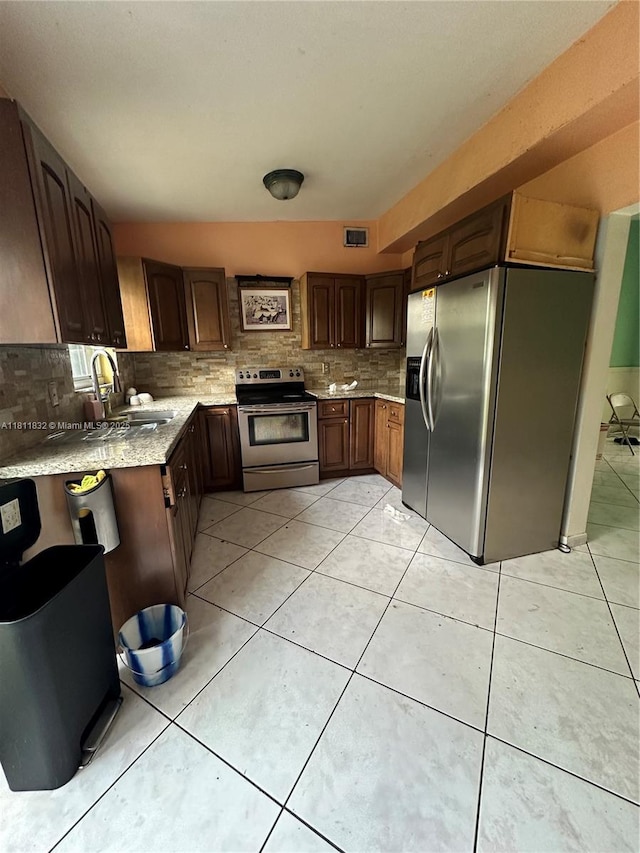 315 W 44th St, Hialeah, FL 33012 - kitchen with appliances with stainless steel finishes, a sink, tasteful backsplash, and light tile patterned floors