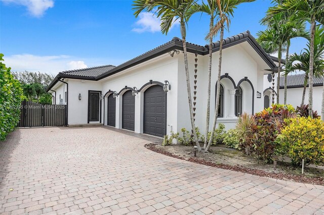 20120 SW 133rd Ave, Miami, FL 33177 - view of front of property featuring an attached garage, decorative driveway, stucco siding, and a tiled roof