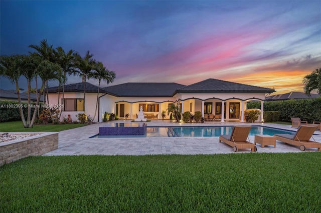20120 SW 133rd Ave, Miami, FL 33177 - back of house at dusk with a yard, a patio, and stucco siding