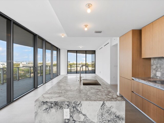 500 Alton Rd Unit 805, Miami Beach, FL 33139 - kitchen featuring a sink, expansive windows, modern cabinets, decorative backsplash, and black electric cooktop