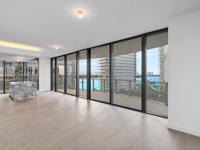500 Alton Rd Unit 805, Miami Beach, FL 33139 - unfurnished room with expansive windows, healthy amount of natural light, wood finished floors, and baseboards