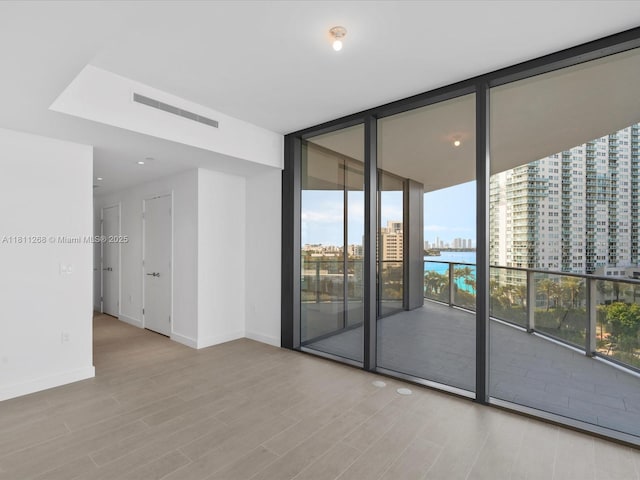 500 Alton Rd Unit 805, Miami Beach, FL 33139 - spare room featuring wood finished floors, a wall of windows, baseboards, a view of city, and recessed lighting