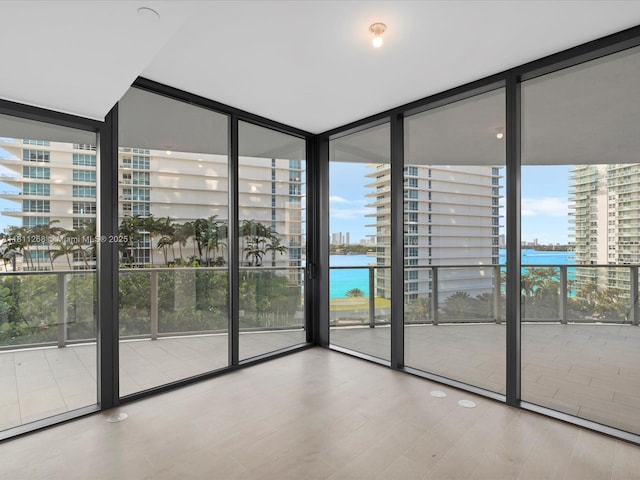 500 Alton Rd Unit 805, Miami Beach, FL 33139 - unfurnished room with a wall of windows, a water view, plenty of natural light, and wood finished floors
