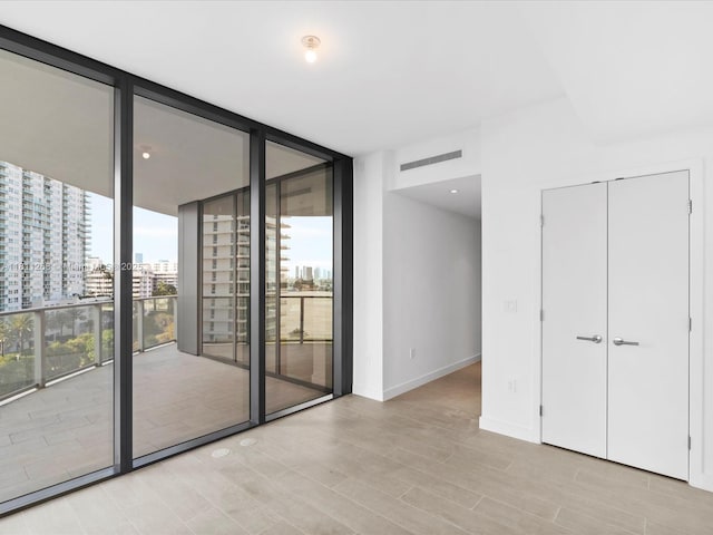 500 Alton Rd Unit 805, Miami Beach, FL 33139 - unfurnished room featuring floor to ceiling windows, light wood finished floors, a city view, and baseboards