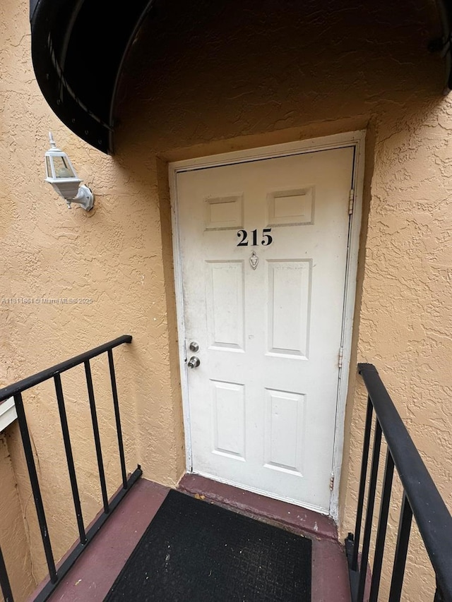 6023 10th Ave N Unit 215, Green Acres, FL 33463 - view of exterior entry featuring stucco siding