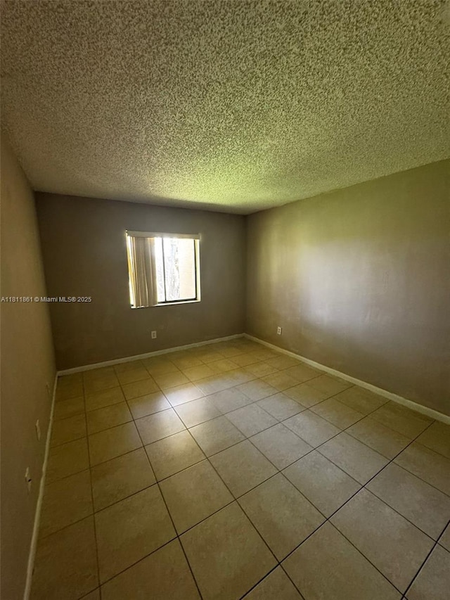 6023 10th Ave N Unit 215, Green Acres, FL 33463 - empty room with a textured ceiling and tile patterned flooring