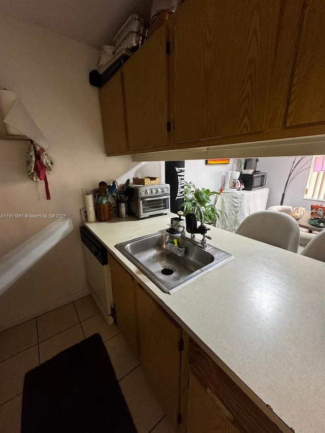 6023 10th Ave N Unit 215, Green Acres, FL 33463 - kitchen with a sink, light countertops, dishwasher, light tile patterned floors, and brown cabinetry
