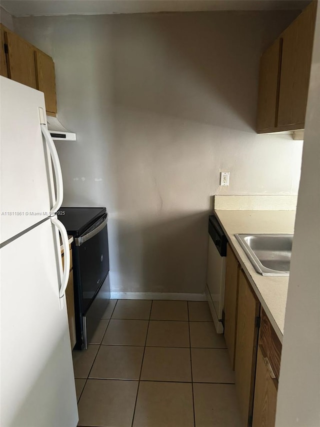 6023 10th Ave N Unit 215, Green Acres, FL 33463 - kitchen with white appliances, light countertops, light tile patterned flooring, range hood, and brown cabinetry