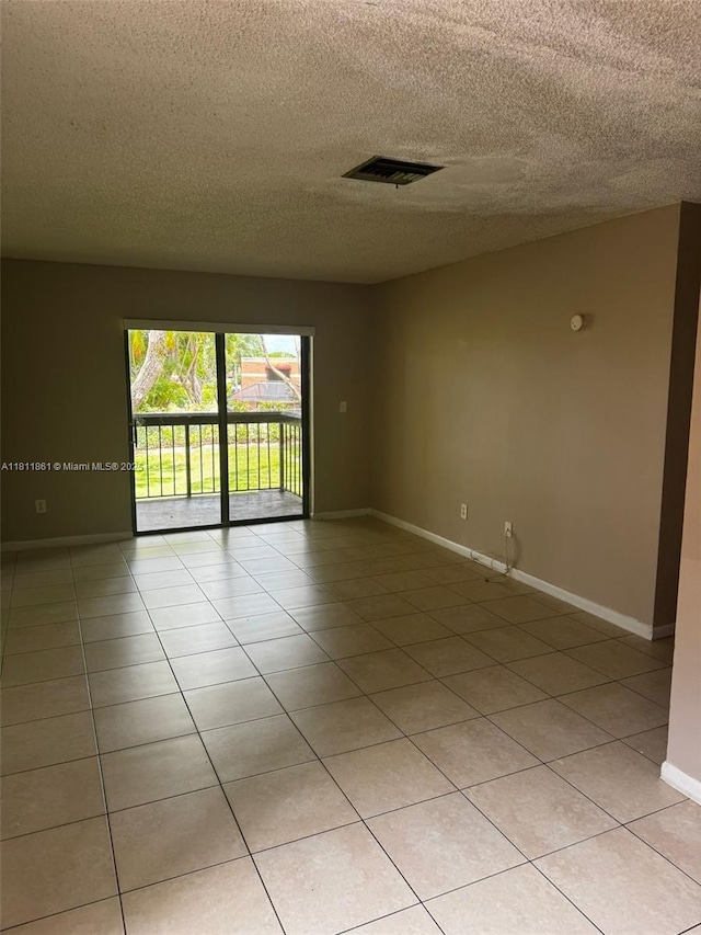 6023 10th Ave N Unit 215, Green Acres, FL 33463 - empty room with a textured ceiling and light tile patterned flooring