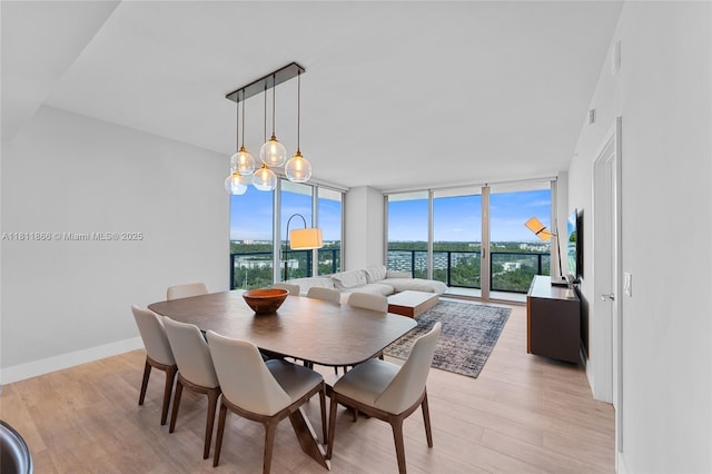 16385 NE Biscayne Blvd Unit 1901Storage, North Miami Beach, FL 33160 - dining space featuring a wall of windows, light wood-style flooring, and baseboards