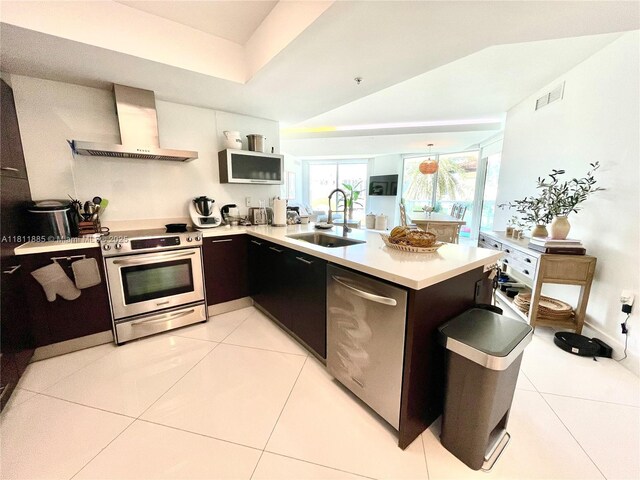 250 Sunny Isles Blvd Unit 3-602, Sunny Isles Beach, FL 33160 - kitchen featuring stainless steel appliances, a sink, wall chimney exhaust hood, light countertops, and light tile patterned floors
