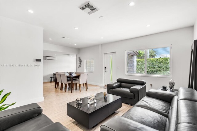 17491 NE 19th Ave, North Miami Beach, FL 33162 - living room featuring an AC wall unit, recessed lighting, light wood-style floors, and baseboards