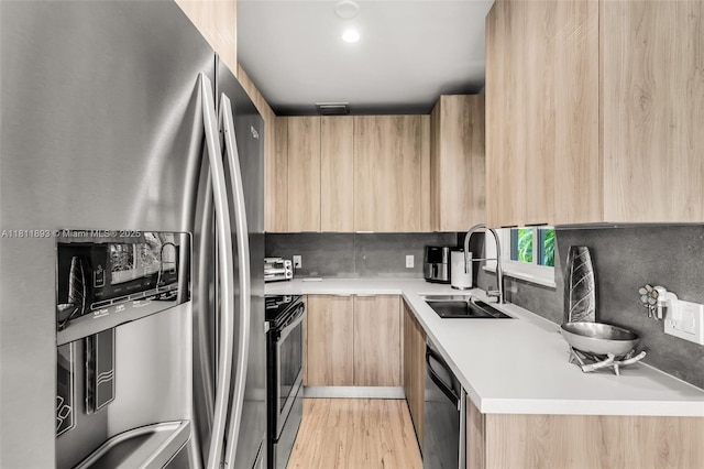 17491 NE 19th Ave, North Miami Beach, FL 33162 - kitchen with stainless steel appliances, light brown cabinetry, modern cabinets, a sink, and light countertops