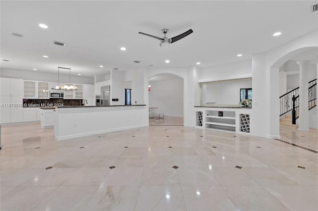 19347 SW 79th Pl, Cutler Bay, FL 33157 - unfurnished living room with arched walkways, ceiling fan, recessed lighting, a sink, and stairs