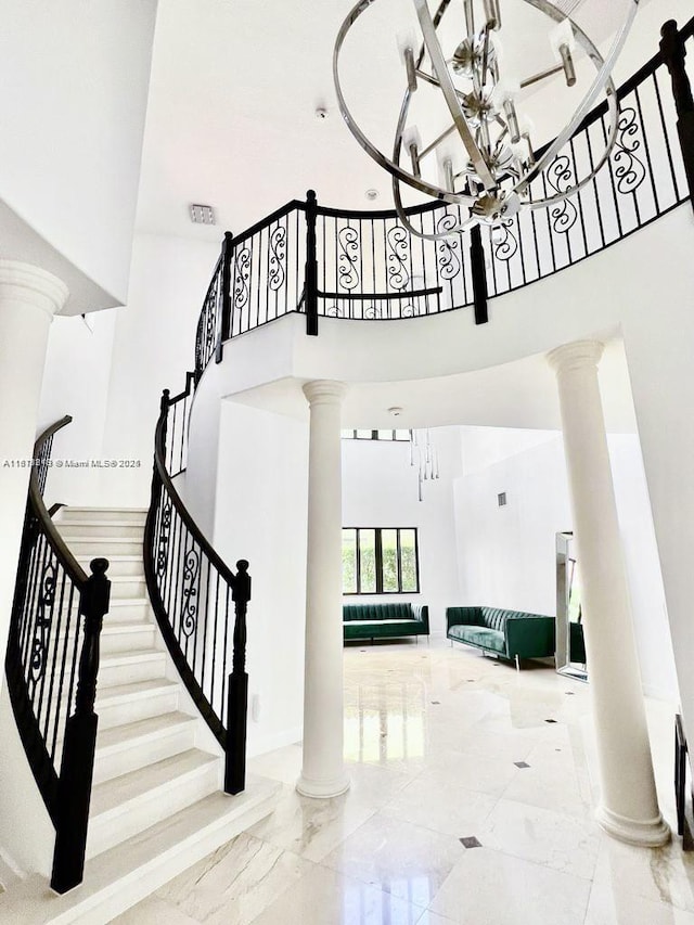 19347 SW 79th Pl, Cutler Bay, FL 33157 - stairs featuring decorative columns, a high ceiling, a chandelier, and marble finish floors