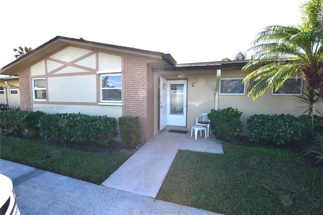 2862 W Crosley Dr Unit C, West Palm Beach, FL 33415 - view of front of home featuring brick siding, stucco siding, and a front lawn