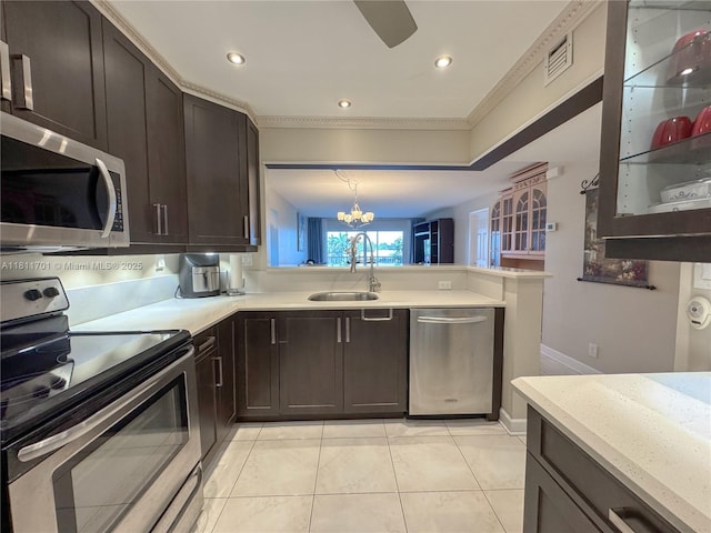 2097 S Ocean Dr Unit 302, Hallandale Beach, FL 33009 - kitchen featuring stainless steel appliances, a sink, a chandelier, light tile patterned floors, and dark brown cabinetry
