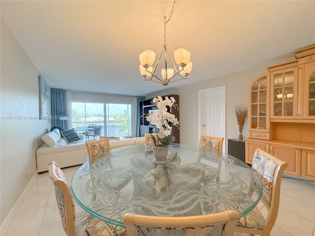 2097 S Ocean Dr Unit 302, Hallandale Beach, FL 33009 - dining area with a chandelier, a textured ceiling, light tile patterned flooring, and baseboards
