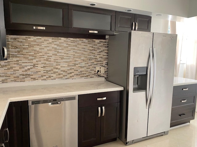 3660 NE 166th St Unit 115, North Miami Beach, FL 33160 - kitchen with stainless steel appliances, decorative backsplash, light countertops, and light tile patterned floors