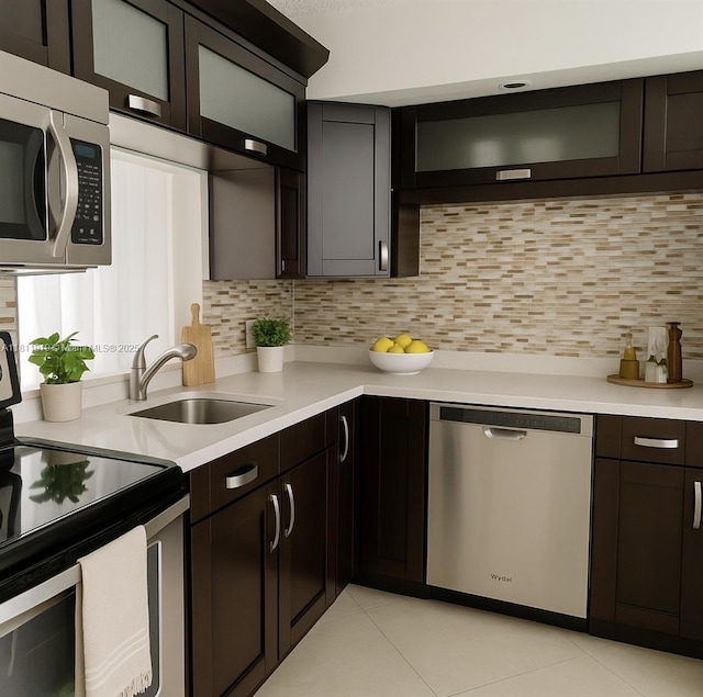 3660 NE 166th St Unit 115, North Miami Beach, FL 33160 - kitchen featuring stainless steel appliances, a sink, light countertops, light tile patterned flooring, and decorative backsplash