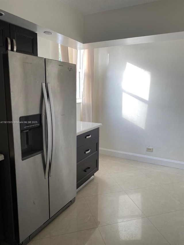 3660 NE 166th St Unit 115, North Miami Beach, FL 33160 - kitchen featuring stainless steel fridge with ice dispenser, light countertops, baseboards, and light tile patterned flooring
