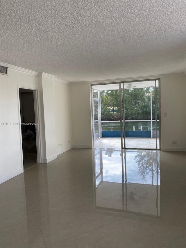 3660 NE 166th St Unit 115, North Miami Beach, FL 33160 - unfurnished room featuring a textured ceiling, crown molding, baseboards, and tile patterned floors