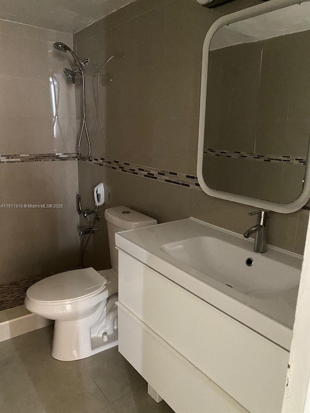 3660 NE 166th St Unit 115, North Miami Beach, FL 33160 - bathroom with a shower stall, vanity, tile walls, toilet, and tile patterned flooring