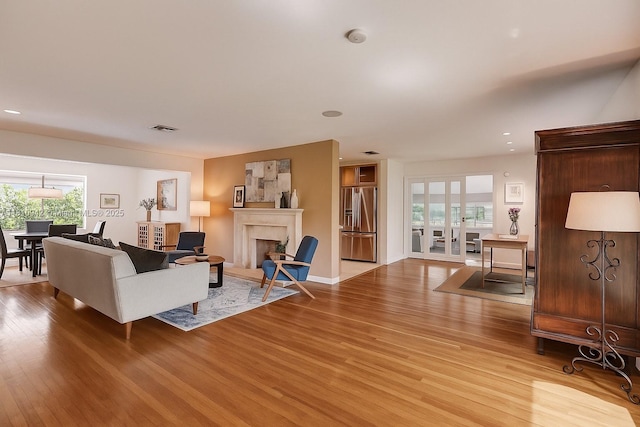 5620 Alhambra Cir, Coral Gables, FL 33146 - living room featuring light wood-type flooring, healthy amount of natural light, a premium fireplace, and recessed lighting