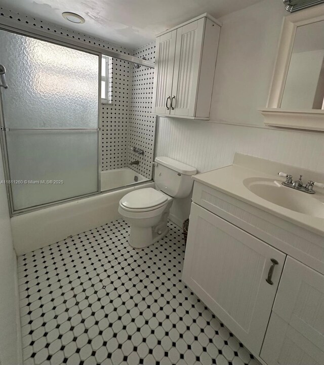 4000 NE 169th St Unit 405, North Miami Beach, FL 33160 - bathroom featuring vanity, combined bath / shower with glass door, toilet, and tile patterned floors