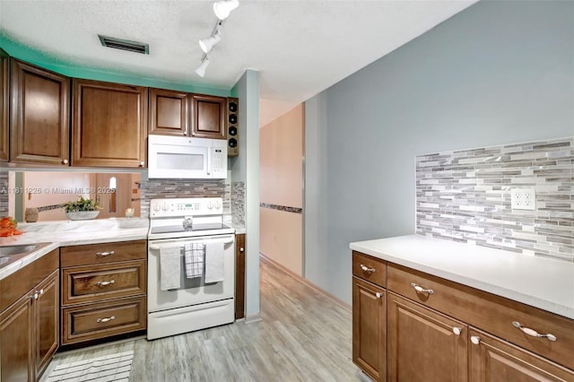 2001 Seagrape Ave, Pembroke Pines, FL 33026 - kitchen featuring white appliances, backsplash, light wood-type flooring, and light countertops