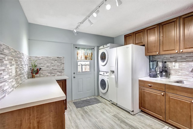 2001 Seagrape Ave, Pembroke Pines, FL 33026 - laundry room featuring stacked washer and clothes dryer, light wood-style flooring, and track lighting