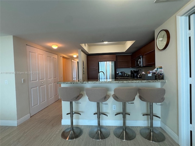 2641 N Flamingo Rd Unit 1001N, Sunrise, FL 33323 - kitchen with stainless steel appliances, baseboards, dark brown cabinetry, and a tray ceiling