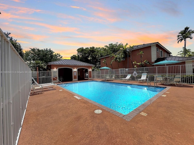 1104 NW 100th Ave, Pembroke Pines, FL 33024 - pool at dusk with a patio and a community pool