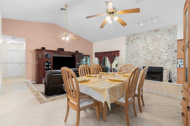 9703 NW 20th St, Coral Springs, FL 33071 - dining space with light tile patterned flooring, a stone fireplace, a ceiling fan, vaulted ceiling, and rail lighting